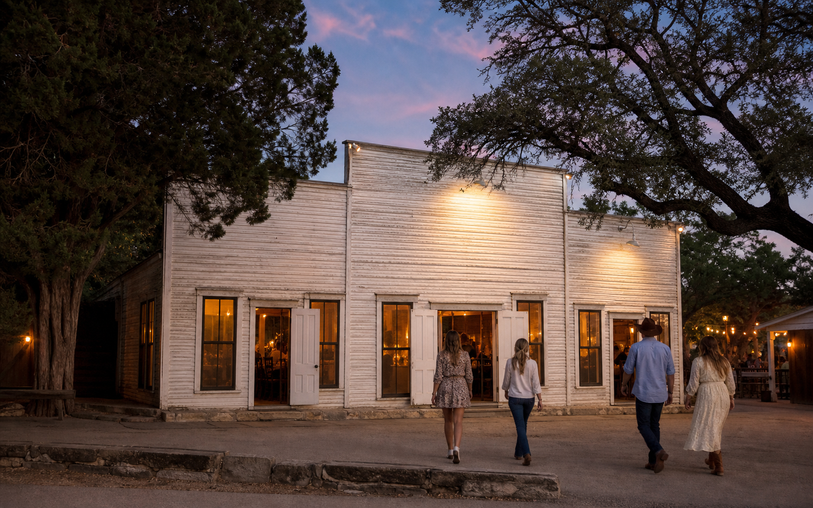 Historic Gruene Hall exterior at dusk beneath mature Texas trees