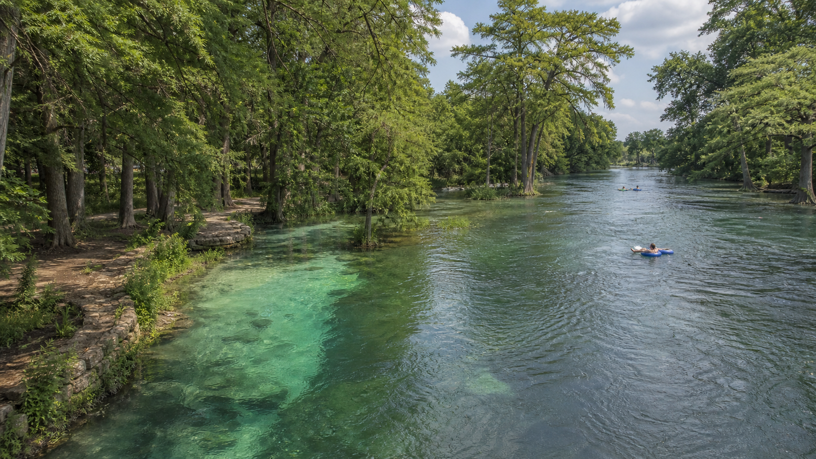 Tubers on a clear tree-lined river in New Braunfels